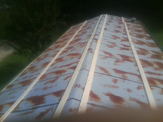 Rusted metal roof panels with new wood purlins before replacement — Storm Damage Roof Repair in Whipple by Roofing Brothers