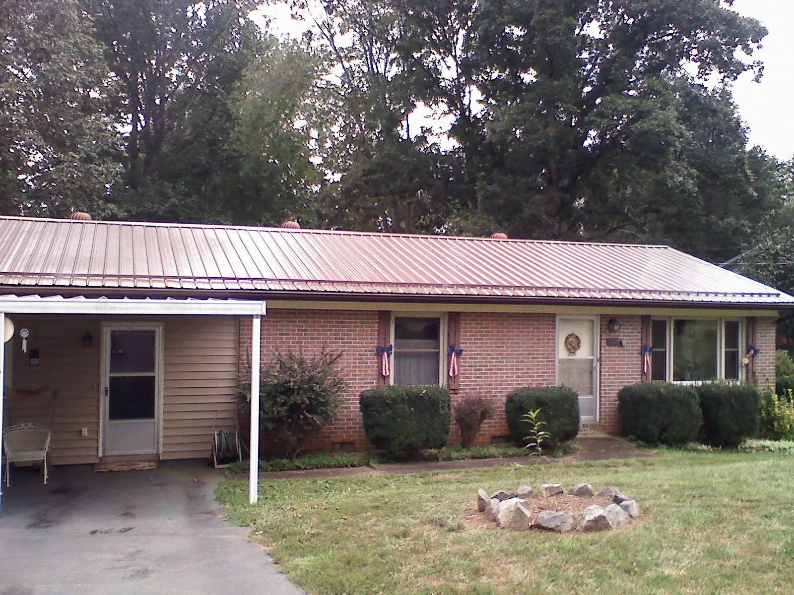 Bronze metal roof and carport on a brick ranch home — Roof Repair work by our crew in Whipple